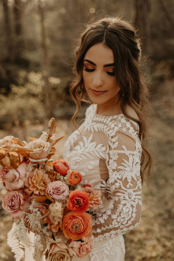 A gorgeous bride holding a bouquet and wearing a boho wedding dress