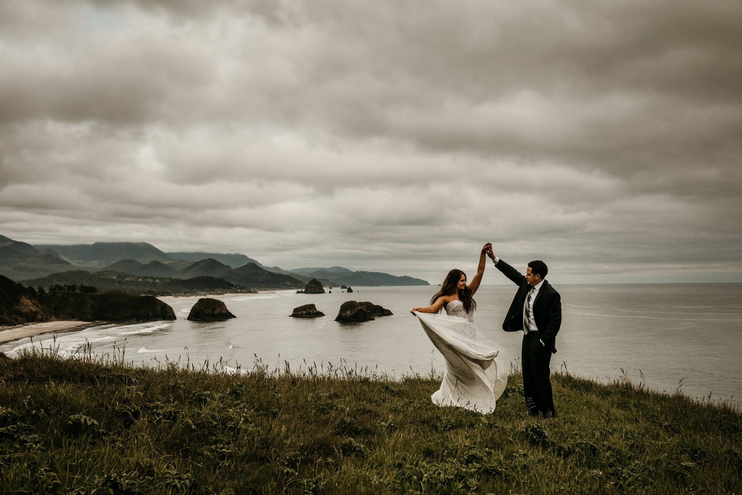 A bride and groom celebrating by dancingm, overlooking the cliffs on the Pacific Ocean, or Pacific Northwest.