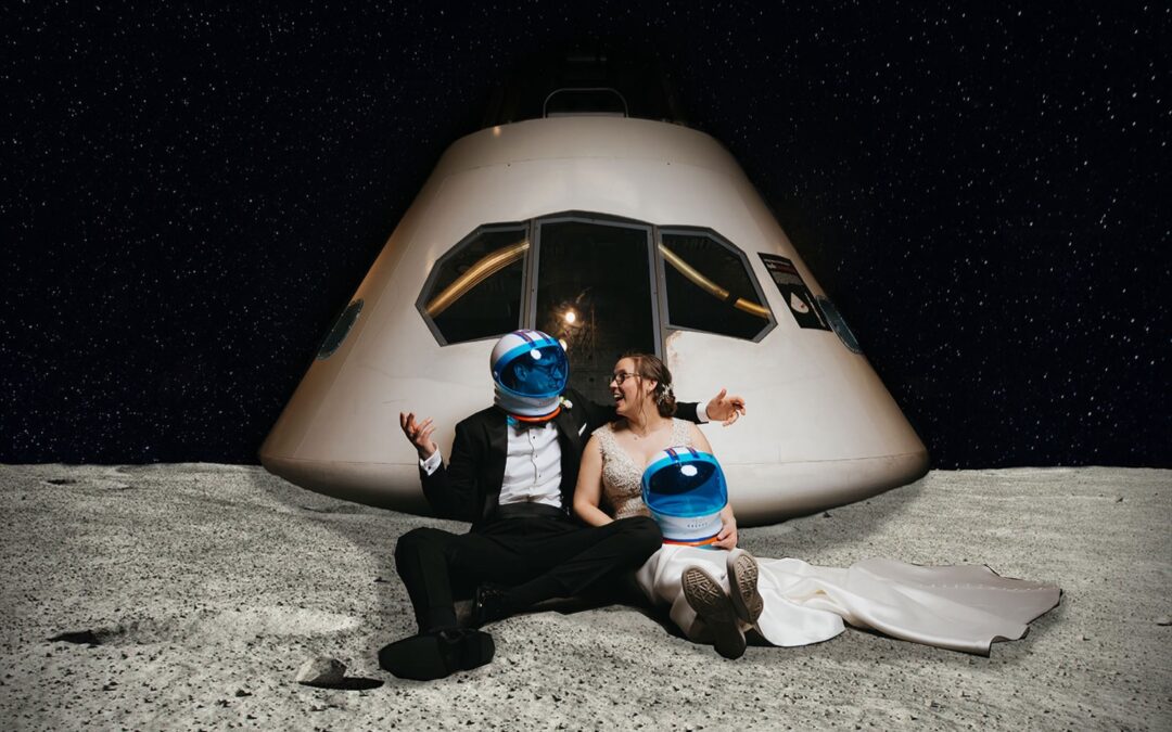 A quirky wedding at Boston's Museum of Science, the bride and groom sitting in front of one of the museum's displays
