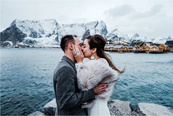 A bride and groom kissing in the rugged landscape of Greenland